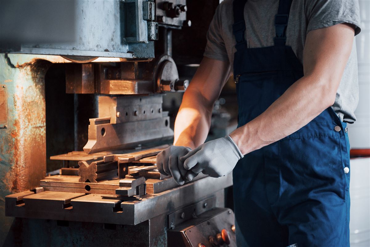 Metallbauer mit Schutzhelm in einer großen Metallbearbeitungsanlage, Fertigung bei Siebert Schweißtechnik und Metallbau